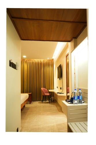 a room with a bed and a desk with a chair at Hotel Surguru in Pondicherry