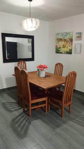 a dining room table with four chairs and a television at Apartment 8, 7373A, Mtedza Rd in Lusaka