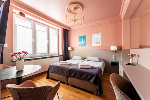 a bedroom with a bed and a table and chairs at Gościniec in Sopot