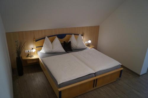 a bedroom with a large bed with two night stands at Haus Garz in Weissensee