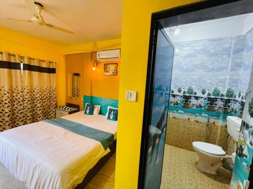 a bedroom with a bed and a bathroom with a toilet at Samantha Inn Beach Resort in Arambol