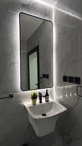a bathroom with a white sink and a mirror at M Residence in Dhahran