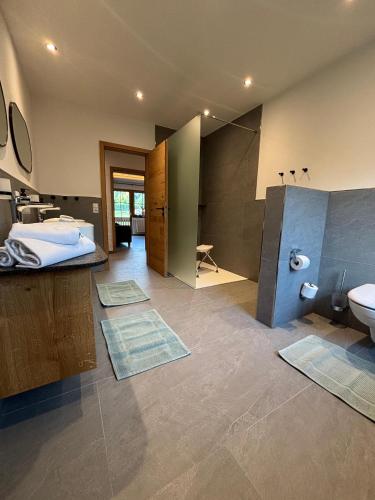 a bathroom with a bed and a sink and a toilet at Ferienwohnungen Holzferienhäuser Leithenwald in Zwiesel