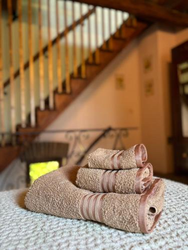 a pile of towels sitting on a bed with a staircase at Fiorire Casale Olistico in Attigliano