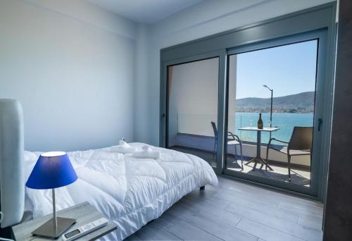 a bedroom with a bed and a view of the ocean at Sea Breeze Stay 2 in Salamina