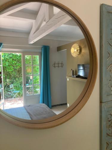 a mirror in a bedroom with a bed and a window at La Vagabonde in Saint-Tropez