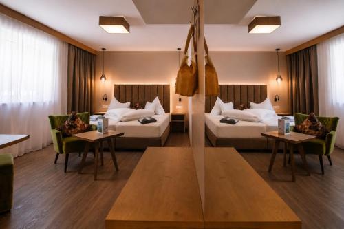 a hotel room with two beds and a table at Hotel Wiese in Sankt Leonhard im Pitztal
