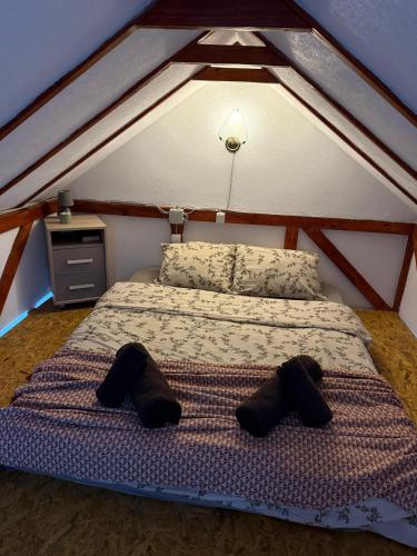 a bed with two pairs of shoes on it at Zmajeva Kuca in Mali Zvornik