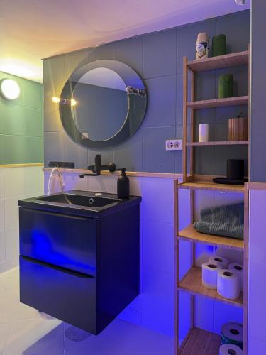a blue bathroom with a sink and a mirror at Willa Wielka Puszcza in Porąbka