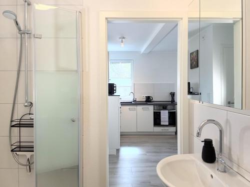 a white bathroom with a sink and a shower at Fewo Diemelsee 4 in Heringhausen