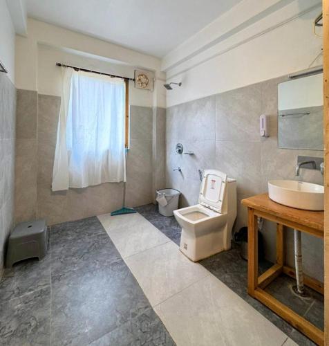 a bathroom with a toilet and a sink at Chhaon Stays in Shoja