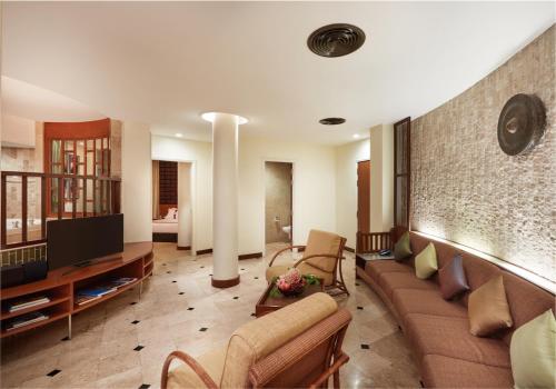 a living room with a couch and a tv at The Davis Bangkok in Bangkok