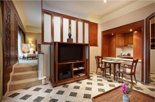 a living room with a television and a kitchen at The Davis Bangkok in Bangkok