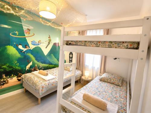 a bedroom with two bunk beds and a mural at Cocon magique - 10min Disneyland parking privé idéal famille in Coupvray