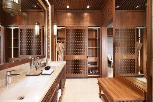 a bathroom with a sink and a large mirror at MĀUA OLEA Ubud by Swiss-Belhotel in Ubud
