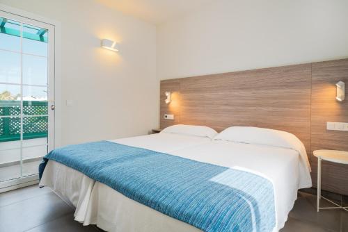 a bedroom with a large bed and a large window at Apartamentos Celeste in Costa Teguise