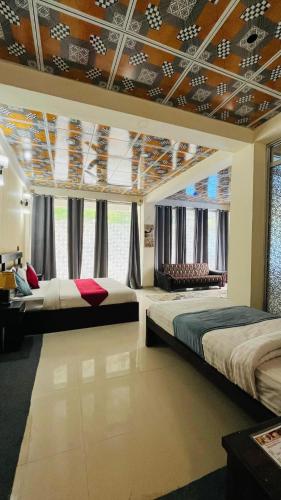 a bedroom with two beds and a large window at Northview Hotel Hunza in Hunza Valley