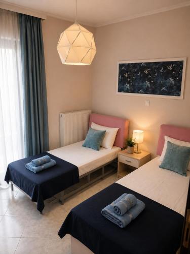 a bedroom with two beds and a window at KilkisLuxuryApartment in Kilkis