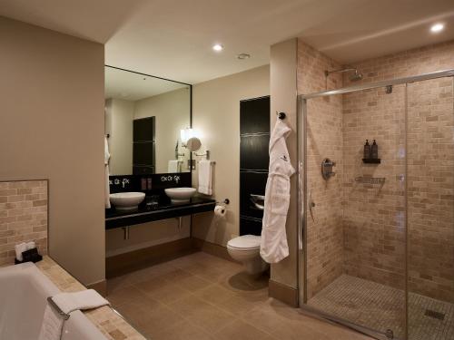 a bathroom with a shower and a toilet and sink at Bowood Hotel, Spa, and Golf Resort in Chippenham