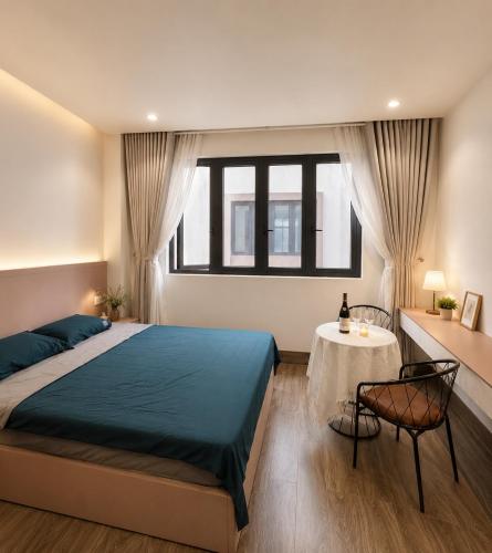 a bedroom with a large bed and a table at U-ViVu Homestay Ocean Park 3 Hưng Yên in Ðình Loan