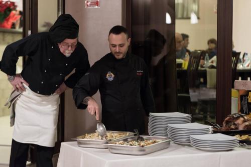 two chefs standing in front of a table with food at Pridvorul Haiducilor in Slănic-Moldova