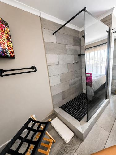 a bathroom with a shower with a glass door at Rudman's Private Love Nest in Boksburg
