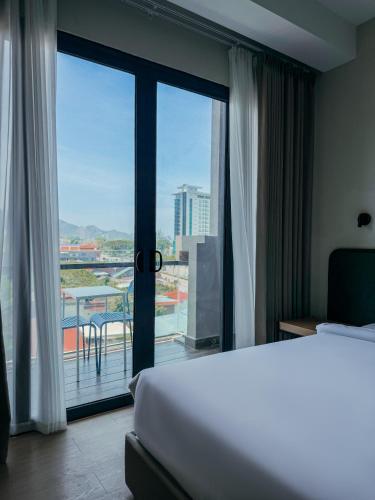 a hotel room with a bed and a balcony at PureJoy Hotel Langkawi in Kuah