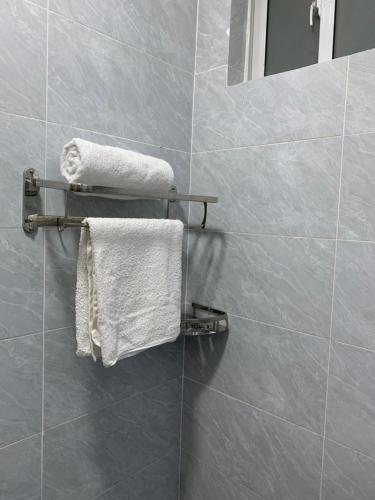 a bathroom with white towels hanging on a wall at EM Homes Modern 1-Bedroom Apartment with Pool 15 Minutes from JKIA Airport in Marimbeti