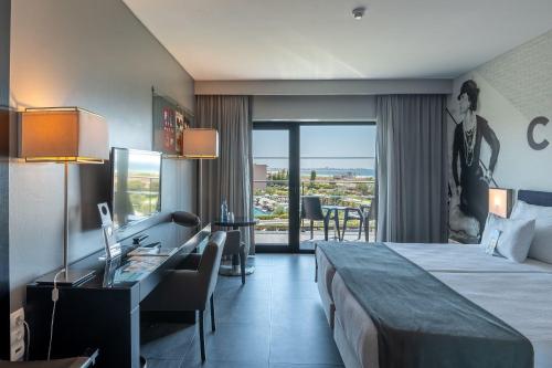 a hotel room with a bed and a desk at Vila Gale Lagos in Lagos