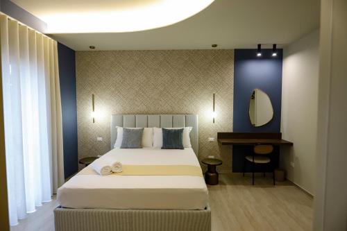 a bedroom with a large bed and a mirror at Seõra Luxury Rooms in Porto Empedocle