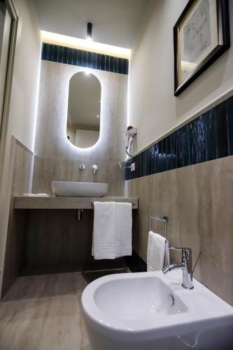 a bathroom with a white sink and a mirror at Seõra Luxury Rooms in Porto Empedocle