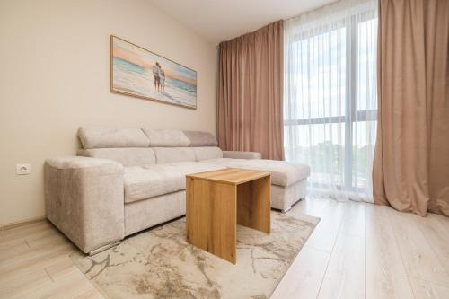 a living room with a couch and a table at River View 1-Bedroom Apartment in Plovdiv