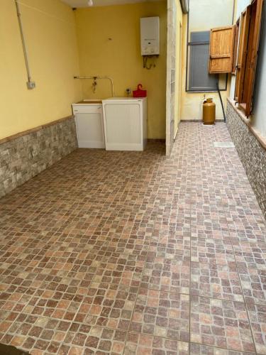 a kitchen with a tiled floor in a room at Villa Irmā in Tertenìa