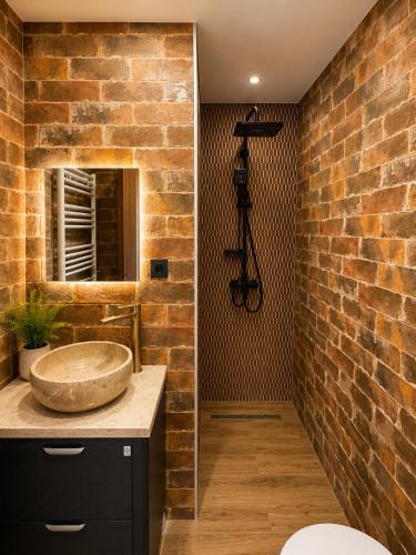 ein Badezimmer mit Waschbecken und einer Ziegelwand in der Unterkunft Hotel Prime in Mzcheta