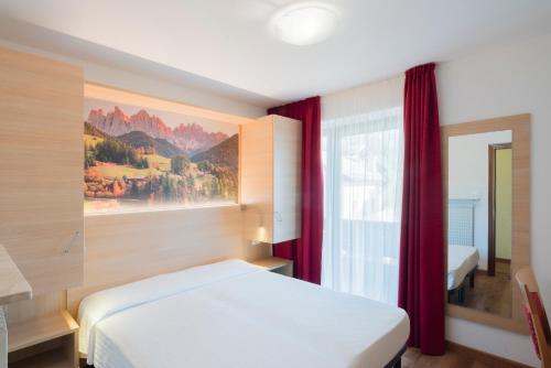 a bedroom with a white bed and a window at Garni Val Udai in Mazzin