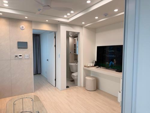 a bathroom with a toilet and a tv on a wall at TRAVELUS Myeongdong 트래블어스 명동 in Seoul