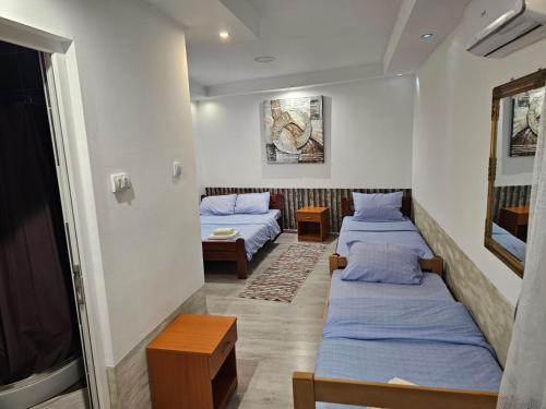 a room with two beds and a flat screen tv at Prenociste Simke 2 in Subotica