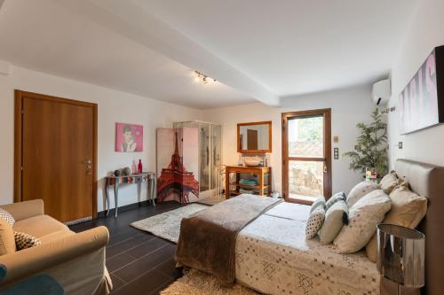 a bedroom with a bed and a couch and a fireplace at Villa Mare Monti in Lumio
