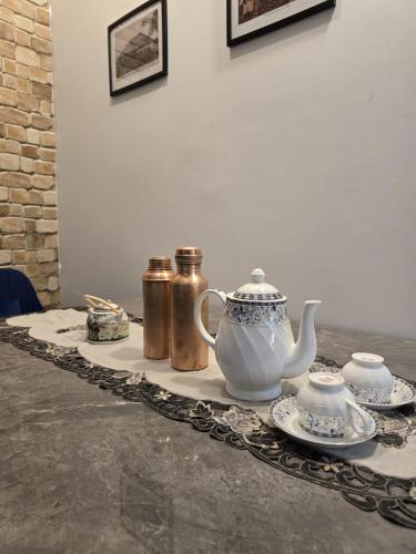 a table with a tea set on a table at Camellia The Bungalow in Dibrugarh