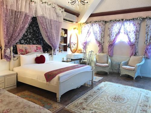 - une chambre avec un lit, des chaises et des rideaux dans l'établissement Socat Home, à Luodong
