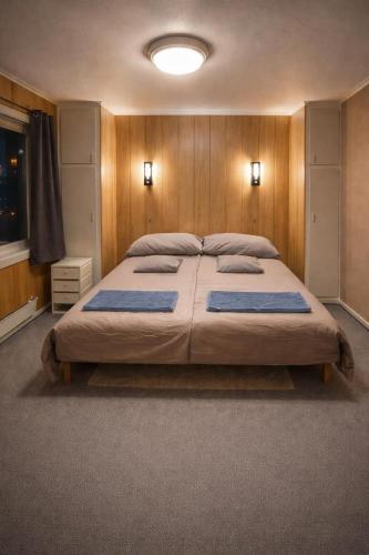 a bedroom with a large bed with wooden walls at Homestay Hammerfest - Central - Lakeview in Hammerfest