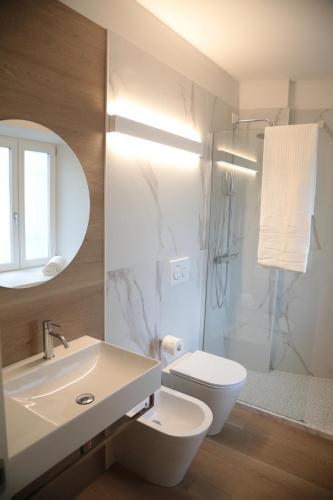 a bathroom with a sink and a toilet and a shower at TAU Rooms Srl in Tricesimo