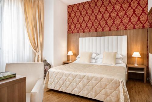 a bedroom with a bed and a red wall at Albergo Rossini 1936 - Small & Charming in Bologna