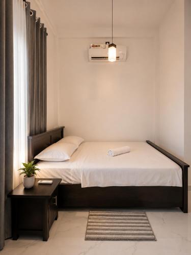 a small bedroom with a bed and a window at Janri Villa in Tangalle