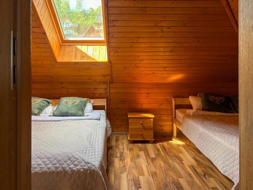 two beds in a log cabin with a window at Willa Wypoczynkowa in Międzybrodzie Bialskie