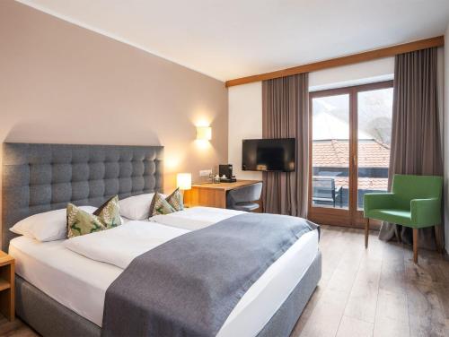 a hotel room with a bed and a desk and a television at Hotel Montis - Active Nature Resort in Brunico