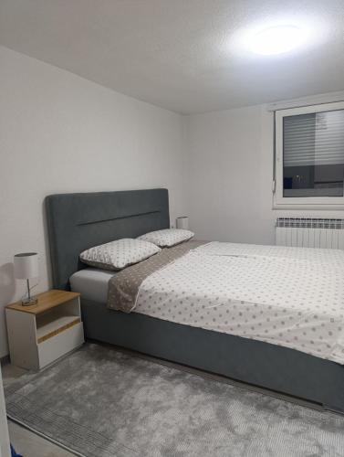 a bedroom with a large bed and a window at Apartment Alan - Modern Stay in Travnik