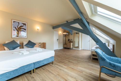 a bedroom with a large bed and blue chairs at Hotel 't Putje in Bruges