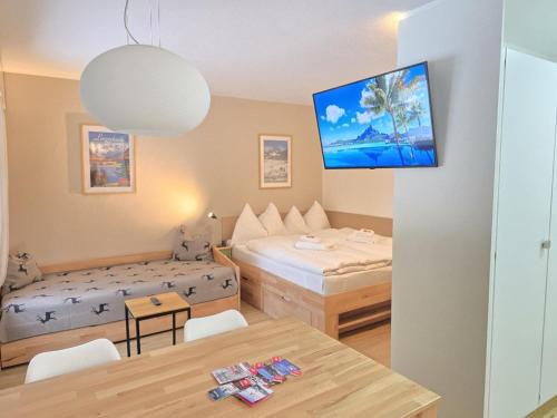 a small room with two beds and a table at Belmont Seegarten in Lenzerheide