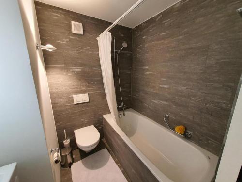 a bathroom with a toilet and a tub and a sink at Ferienwohnung Selina in Lenzerheide